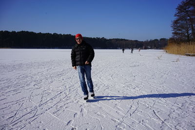 Full length of person standing on snow covered field