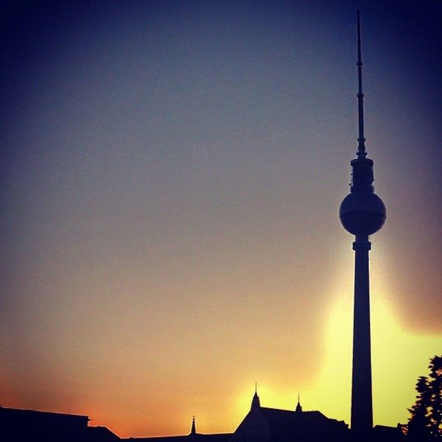 architecture, built structure, communications tower, building exterior, copy space, clear sky, sunset, tower, spire, low angle view, tall - high, communication, silhouette, television tower, orange color, high section, blue, no people, city, outdoors