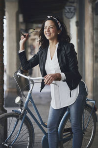 Portrait of smiling young woman with bicycle