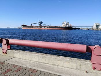 Pier over sea against clear blue sky