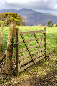 Fence on field against mountains