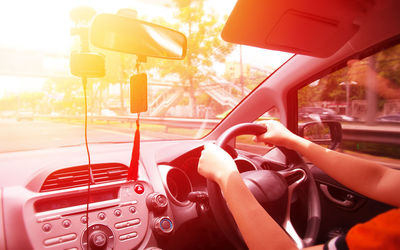 Cropped hands of man driving car