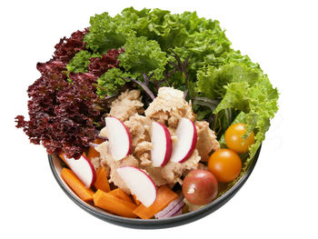 Close-up of chopped fruits in plate against white background