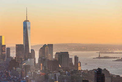 Modern buildings in city against sky during sunset