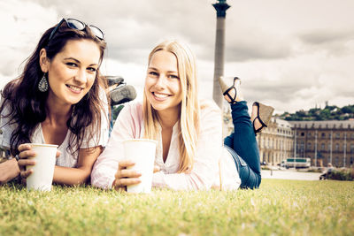 Happy friends enjoying at park against sky