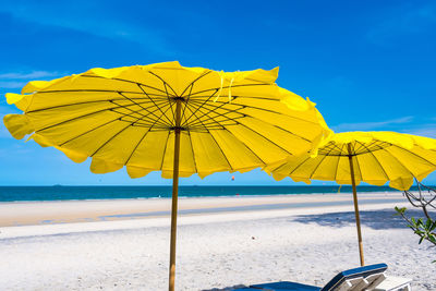 Yellow umbrella on beach against sky