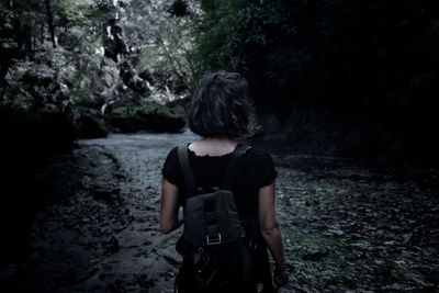 Rear view of woman standing in forest