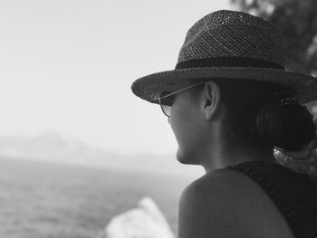 Close-up of young woman against sea against clear sky