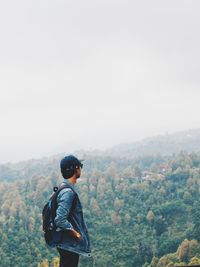 Rear view of man standing against clear sky