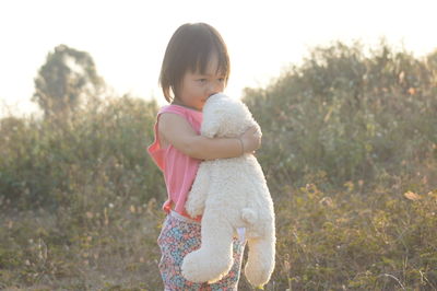 Cute baby girl standing on field