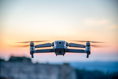 Low angle view of airplane flying against sky during sunset