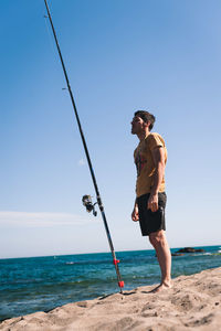 Man on beach against clear sky