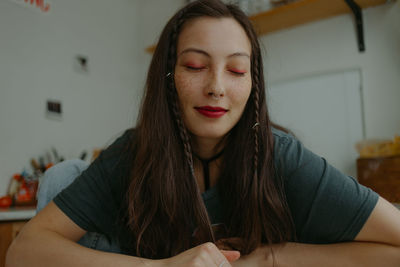 Portrait of young woman sitting at home