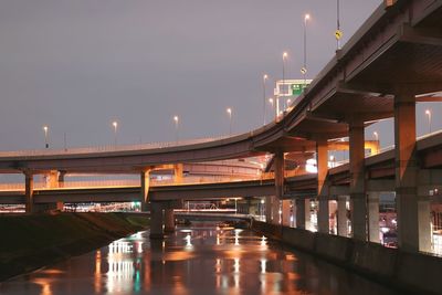 Illuminated bridge over river at night