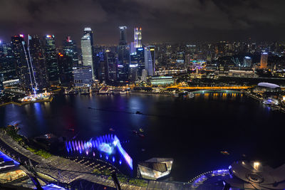 High angle view of illuminated city by river at night