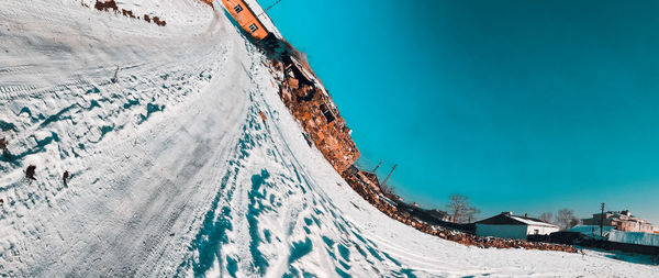 Panoramic shot of snow covered mountain against blue sky