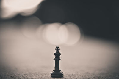 Close-up of illuminated chess pieces against sky at sunset