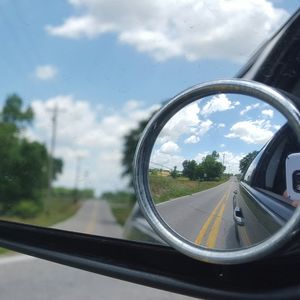 Reflection of clouds in side-view mirror