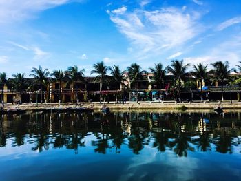 Reflection of palm trees in swimming pool against sky