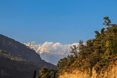 Scenic view of mountains against blue sky