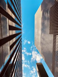 Low angle view of modern buildings against blue sky