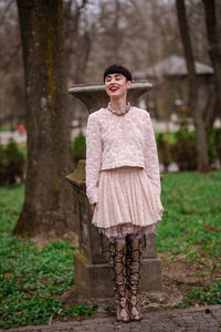 Portrait of woman standing against tree