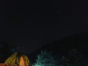 Low angle view of illuminated tent against sky at night