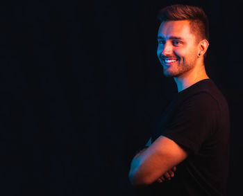 Man standing against black background