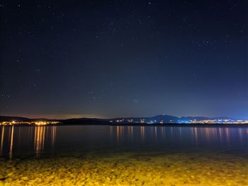 Scenic view of lake against sky at night