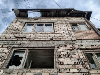 Low angle view of abandoned building against sky