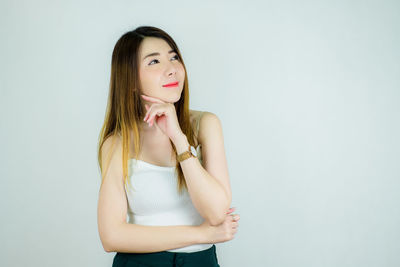 Beautiful young woman smiling against white background