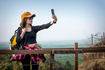 Full length of man photographing while standing on railing