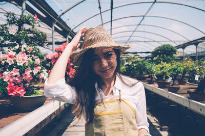 Portrait of smiling woman standing against plants