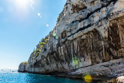 Low angle view of rock formation in sea against sky