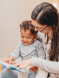 Smiling mother playing with son at home