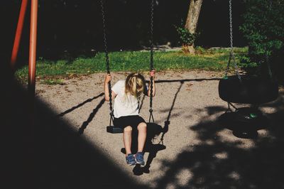 Rear view of woman on swing at playground