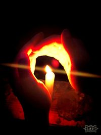 Close-up of lit candle in dark room