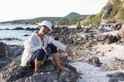 Portrait of a happy mature woman smiling outdoors. happy smiling mature woman on the rock 