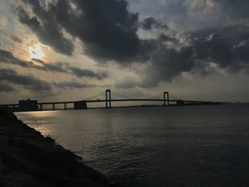 Bridge over calm sea against sky
