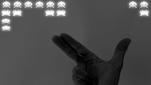 Close-up of person hand against illuminated wall