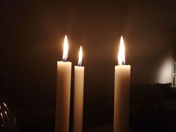 Close-up of lit candles in darkroom