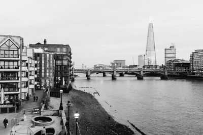 Bridge over river against buildings in city