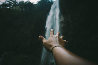 Midsection of man against waterfall