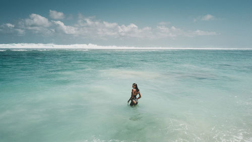 Man swimming in sea against sky