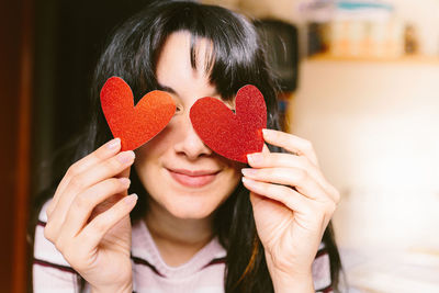 Portrait of young woman holding heart