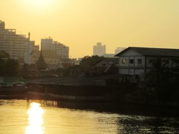 Sunset over river with buildings in background