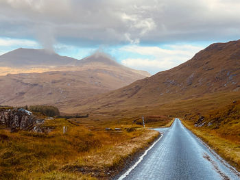 Road amidst mountains against sky