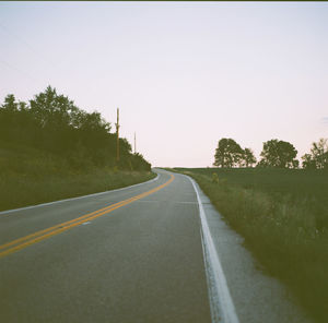 Empty road along trees