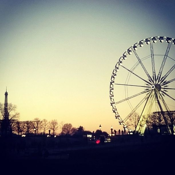 ferris wheel, amusement park, amusement park ride, clear sky, arts culture and entertainment, low angle view, silhouette, copy space, built structure, sky, architecture, dusk, sunset, outdoors, building exterior, tree, no people, fun, large, big wheel