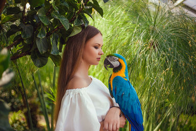 Close-up of woman with parrot